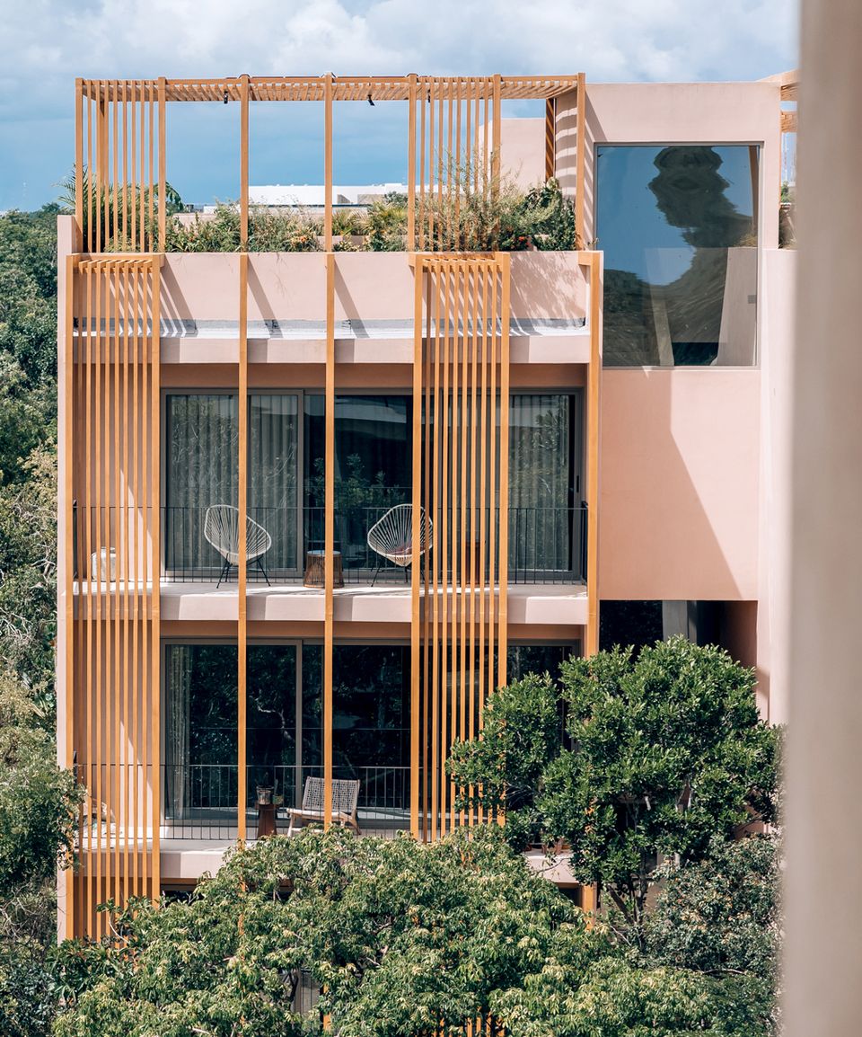 Aflora Tulum apartment tower with a timber lattice and greenery