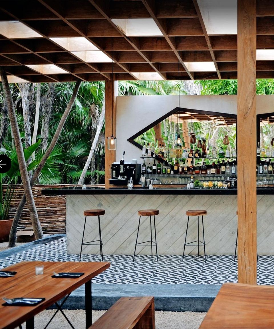 Bar and terrace of the Arca restaurant under a timber canopy in the jungle