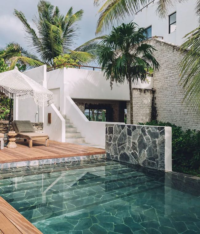 Pool and white terraces of El Chiringuito hotel among palm trees